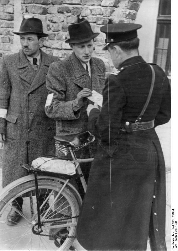 Polish “navy-blue policeman” checking identity cards by the Kraków Ghetto. Photo credit: Wikimedia Commons