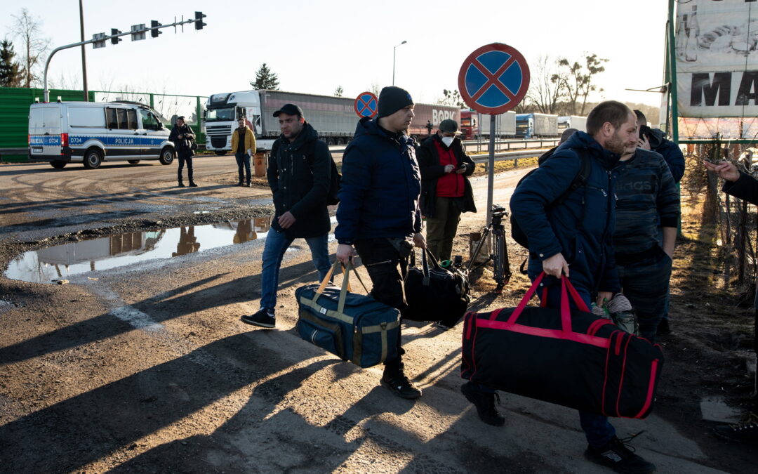 As thousands flee Ukraine, others return from Poland to defend their homeland